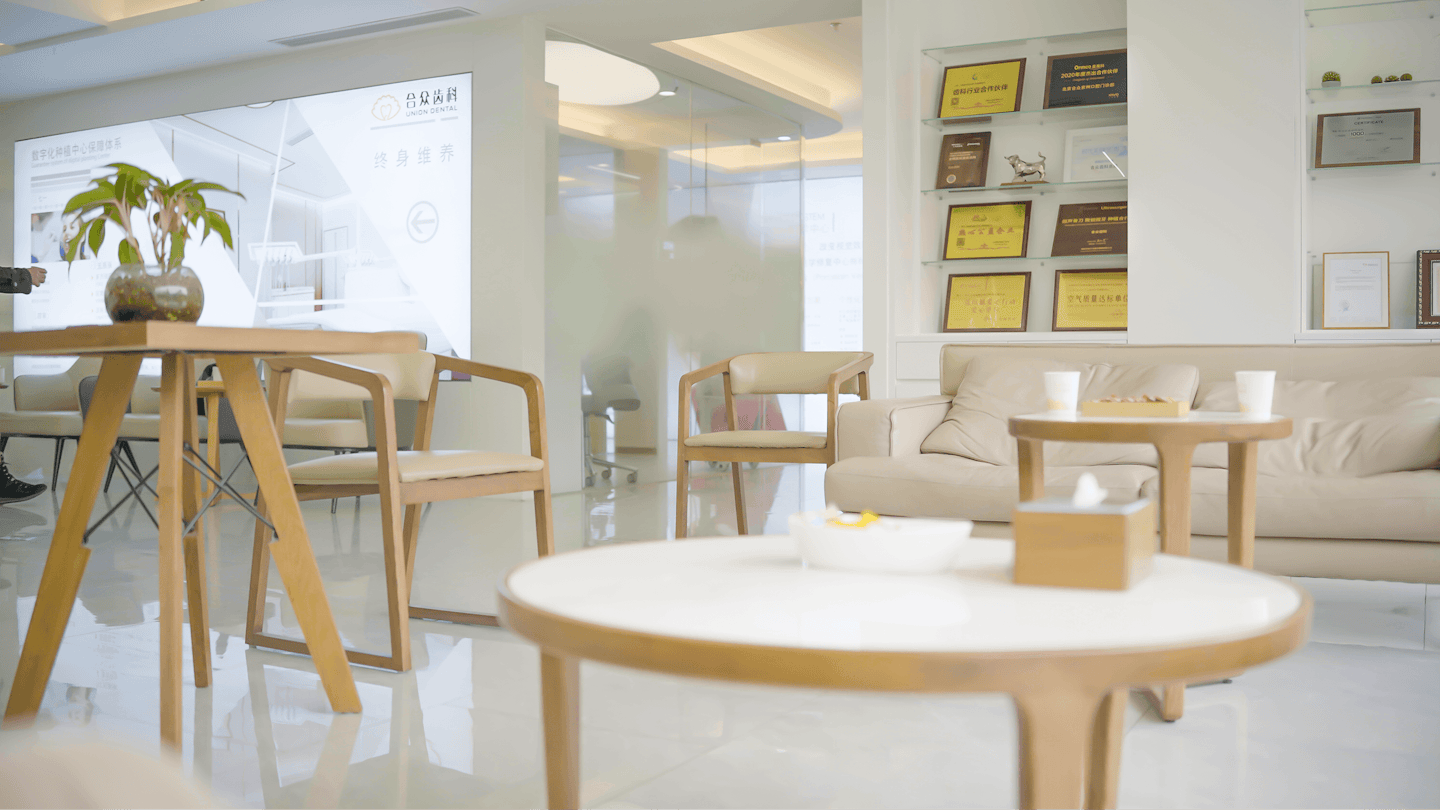 Moderne professionelle Wartezone mit Stühlen und einem beigen Sofa.